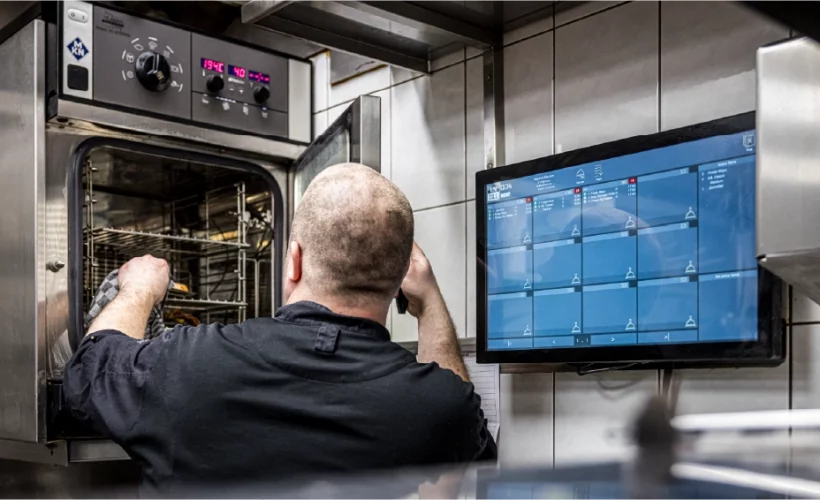 jks keukenpersoneel bij keukenscherm en oven