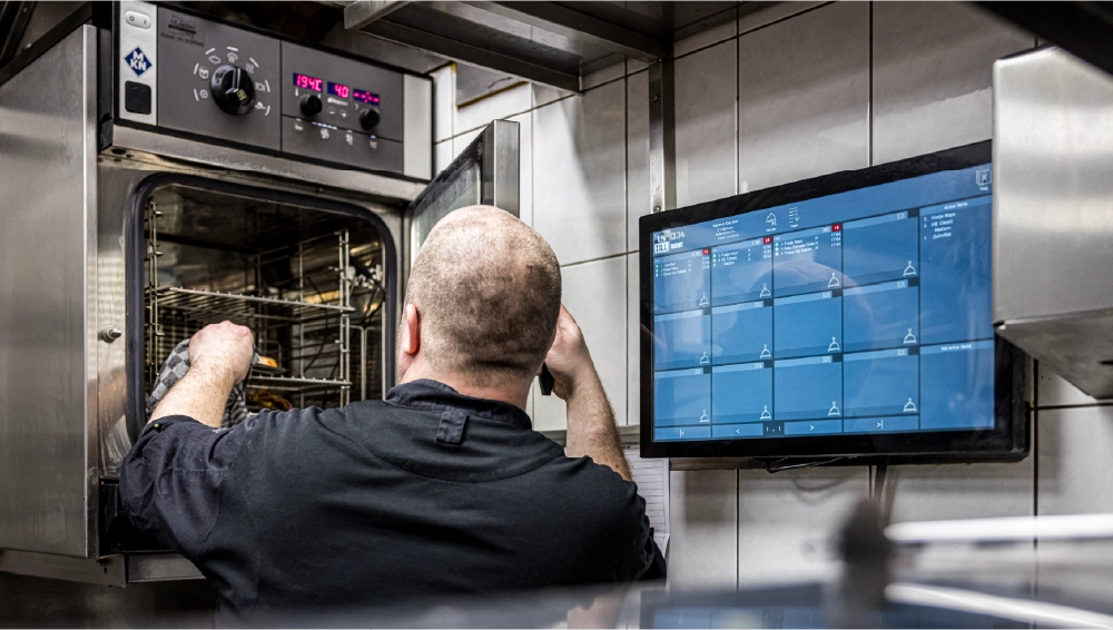 jks keukenpersoneel bij keukenscherm en oven