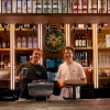 Ondernemer en adviseur achter de bar met handheld