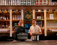 Ondernemer en adviseur achter de bar met handheld