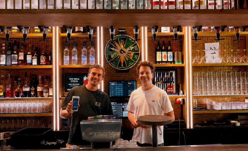 Ondernemer en adviseur achter de bar met handheld