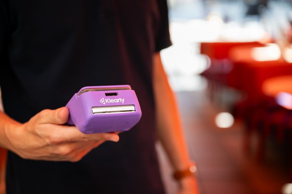 bediening met klearly betaalterminal in de hand